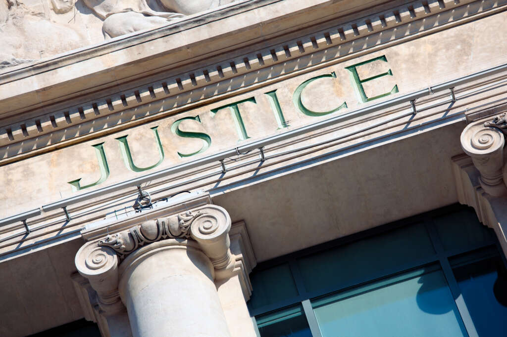 Image of a courthouse with the word justice on it